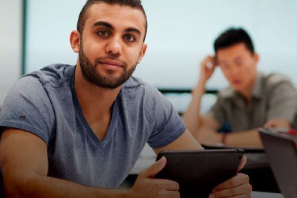 Male student using tab in the classroom