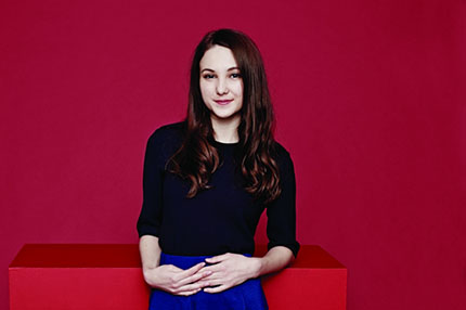 Female student against red wall