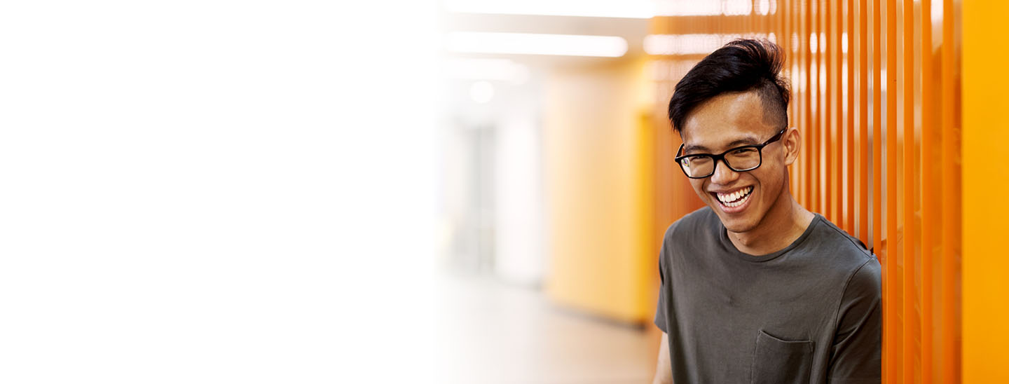 Student happy near orange wall