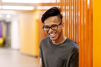 Student happy near orange wall